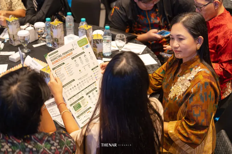 Peserta di meja bundar membaca lembar rencana proyek bisnis bersama